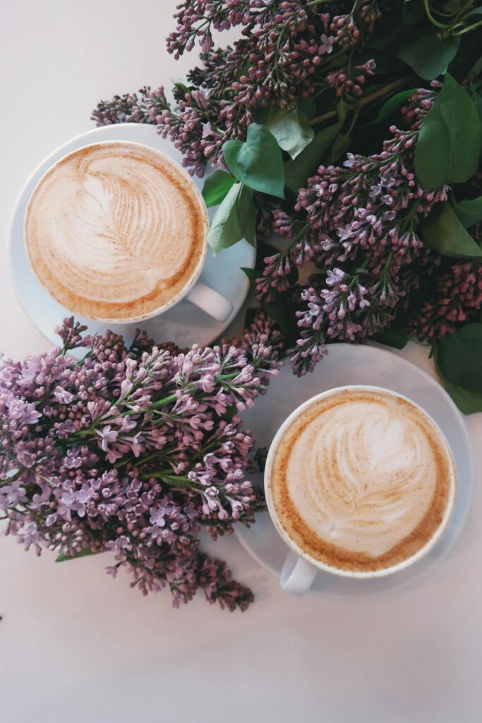 نصائح لتخزين القهوة في الكوفيهات Artistic latte art surrounded by blooming lilac flowers creates a cozy, aesthetic vibe.